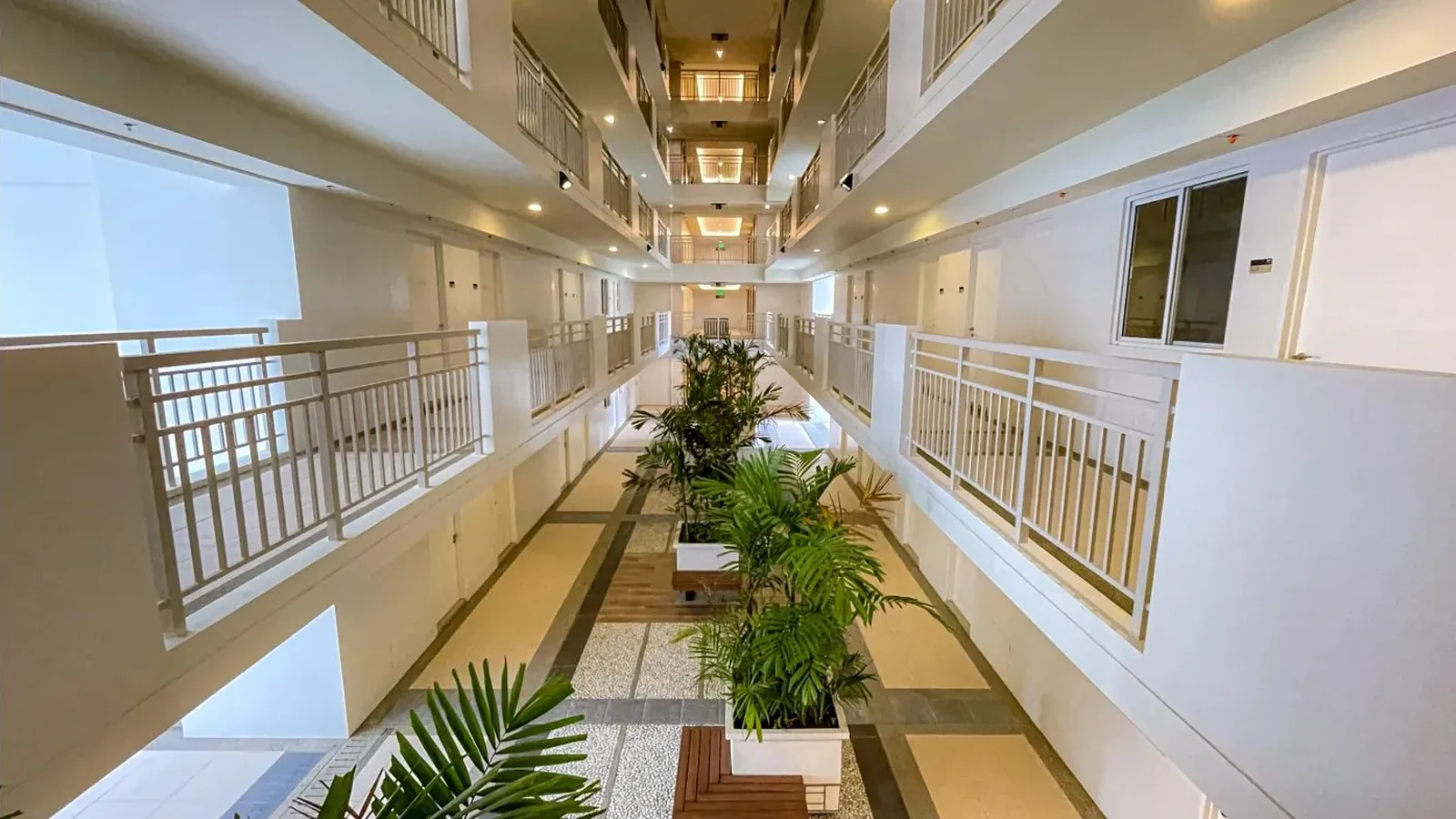 Landscaped atrium corridor with planters and open-air breezeway at Kai Garden Residences, DMCI Homes condo in Mandaluyong, actual photo
